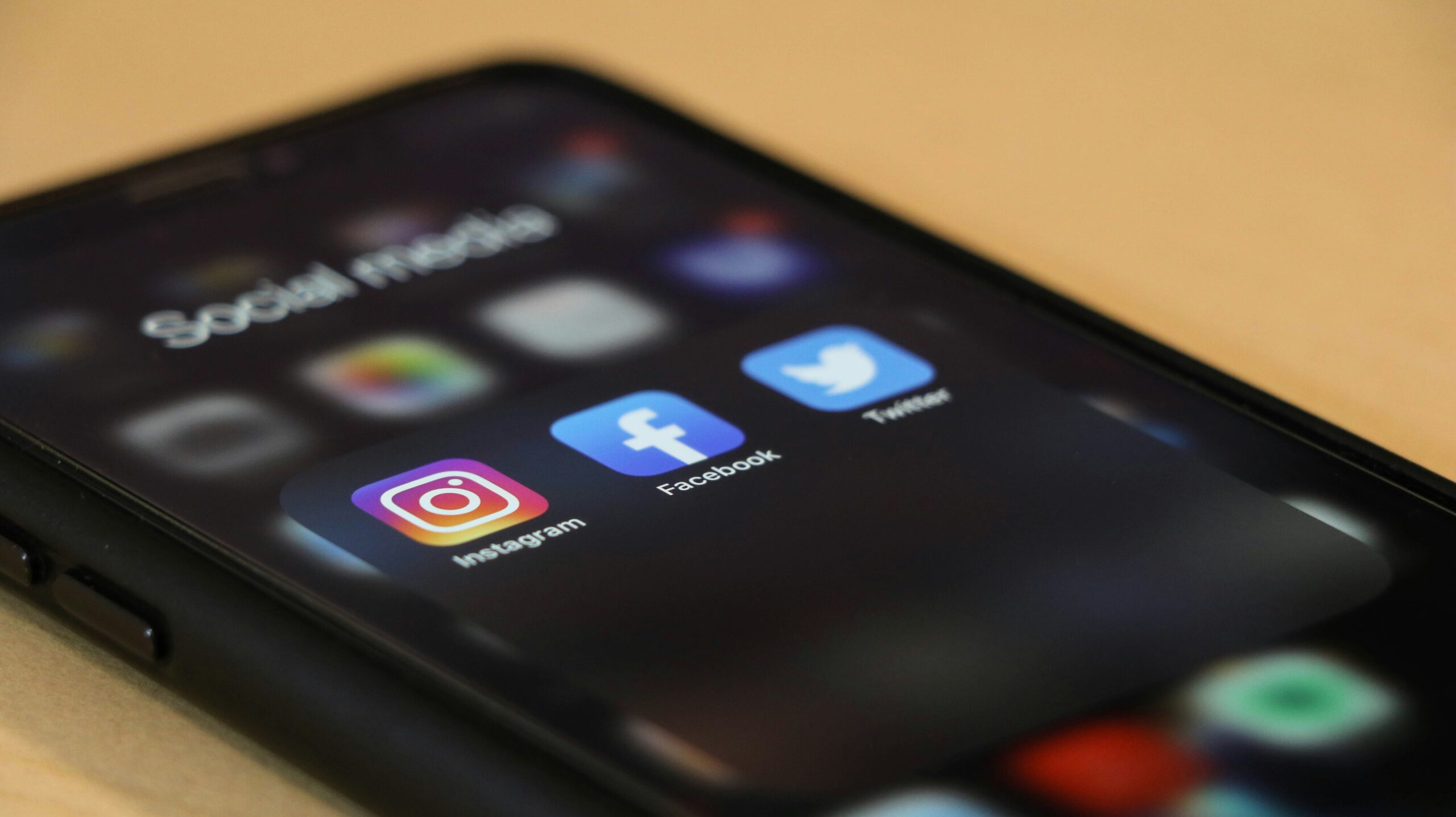 phone on table showing social media apps like instagram, facebook, and twitter